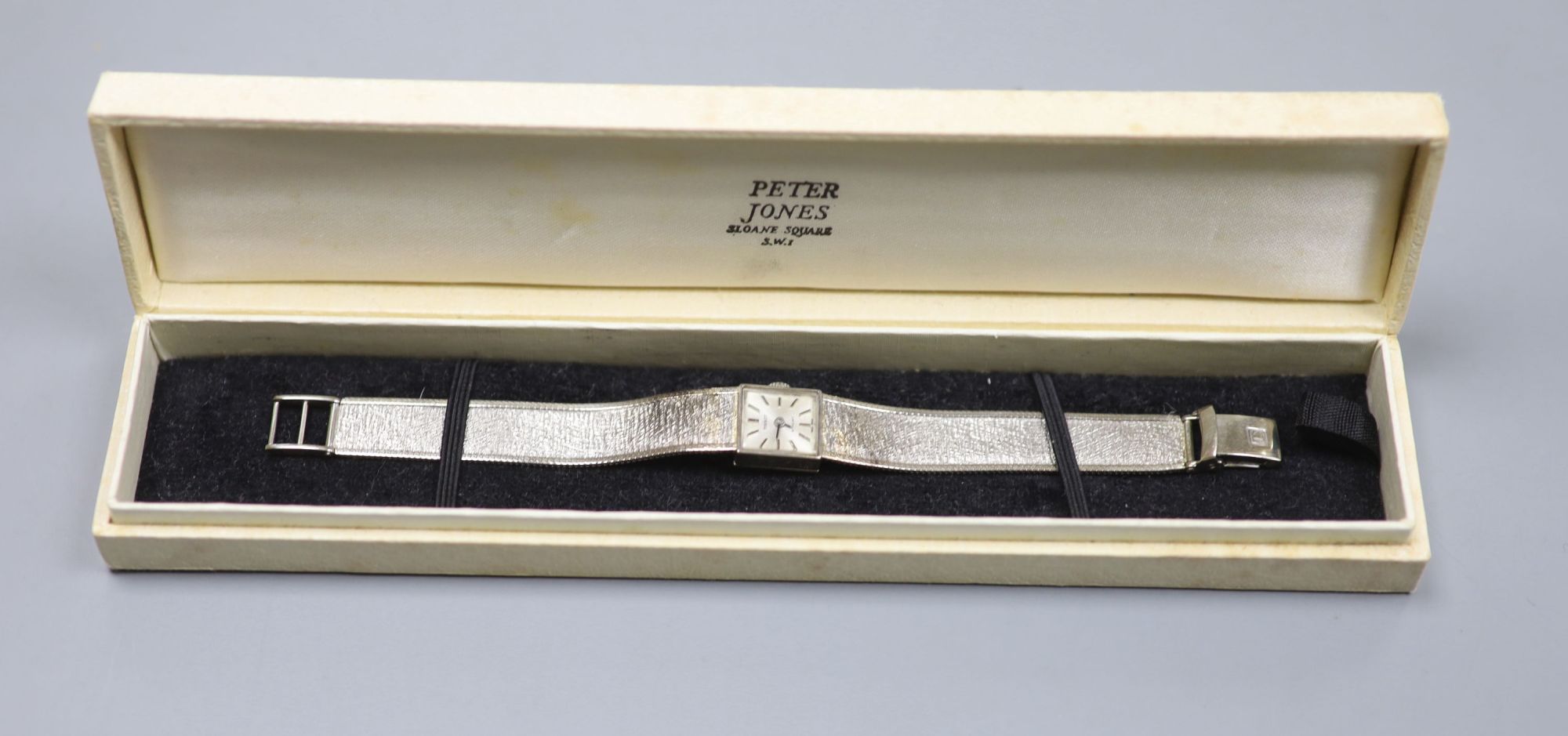 A ladys textured 9ct white gold Tissot manual wind bracelet wrist watch, overall length 17cm, gross 22 grams.